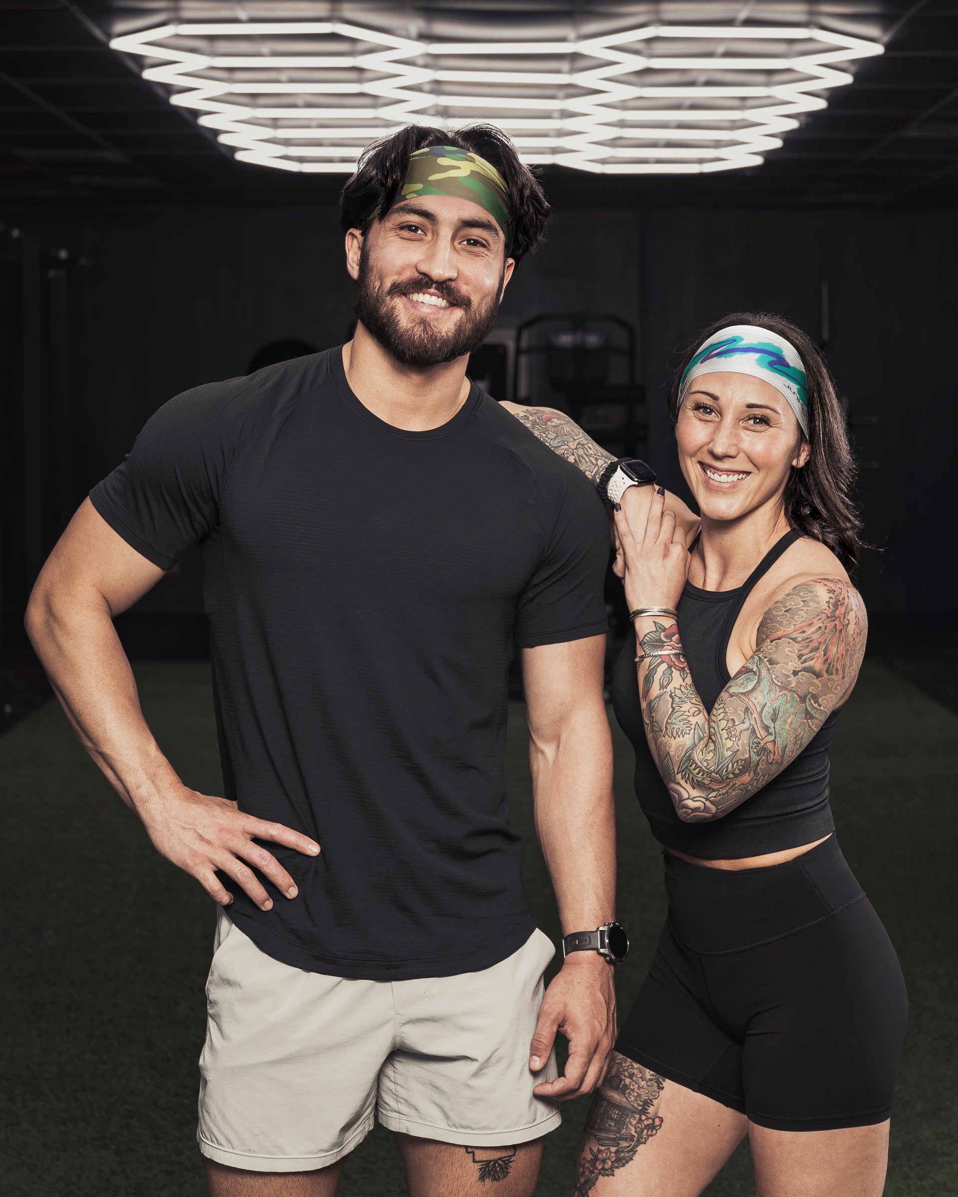 Two people standing together in a dark indoor gym.