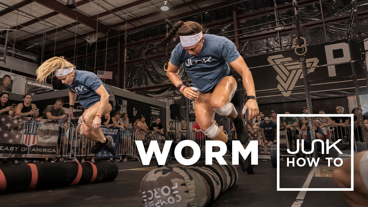 Two athletes do burpee over worm at a crossfit competition, the text overlay says “WORM: JUNK How To” 
