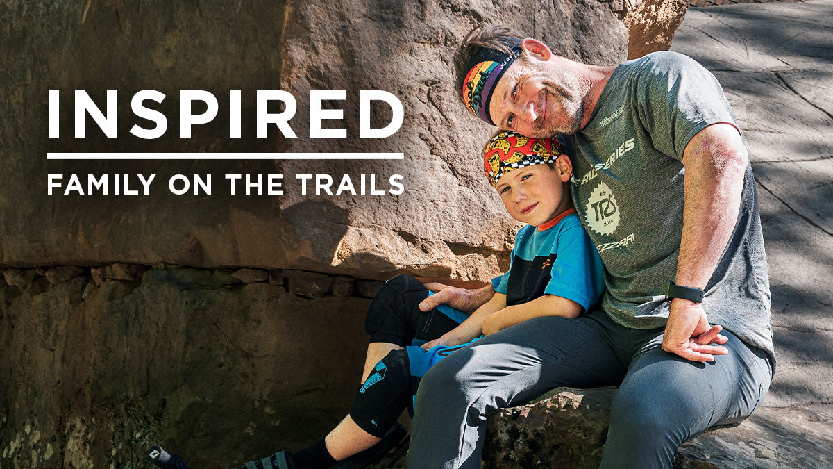 Inspired: Family on the Trails - Father and son wearing biking gear on a rock formation, the text on the screen reads family on the trails