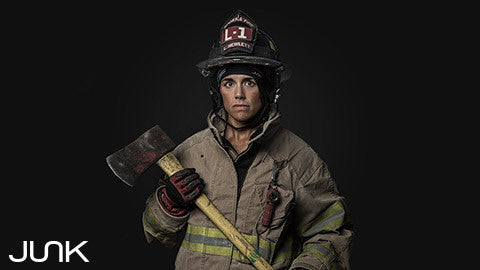 Firefighting woman in full gear with black background