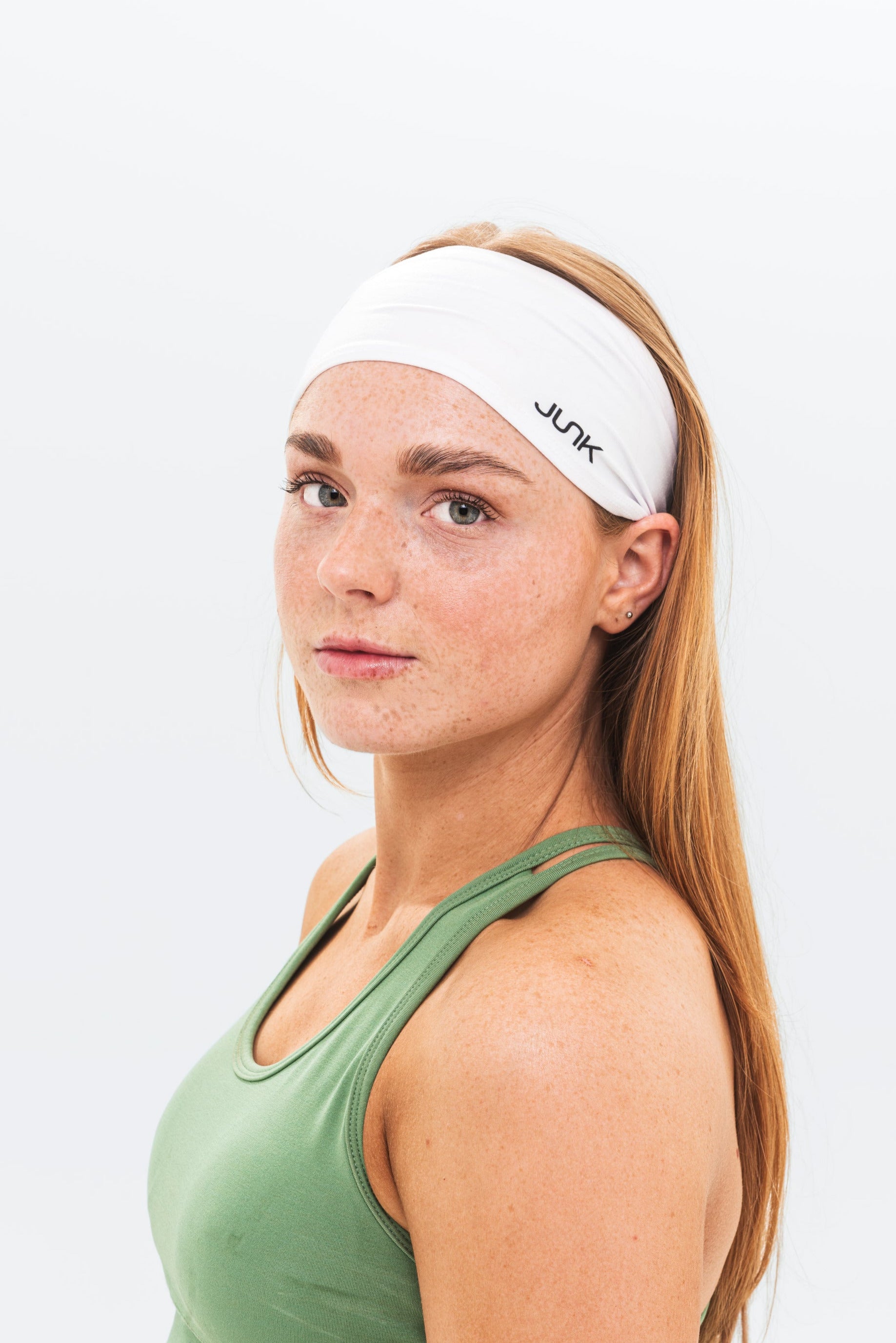 Woman wearing a white headband with 'JUNK' branding on a light gray background