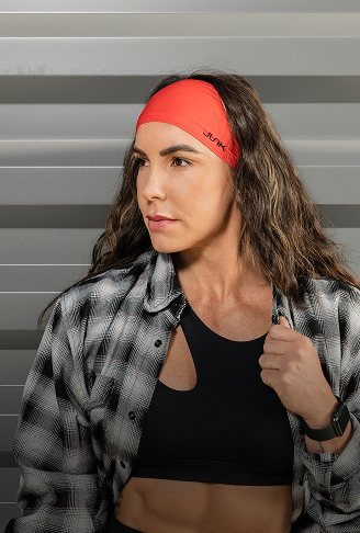 Woman wearing a red headband with a 'JUNK' brand logo against a gray background