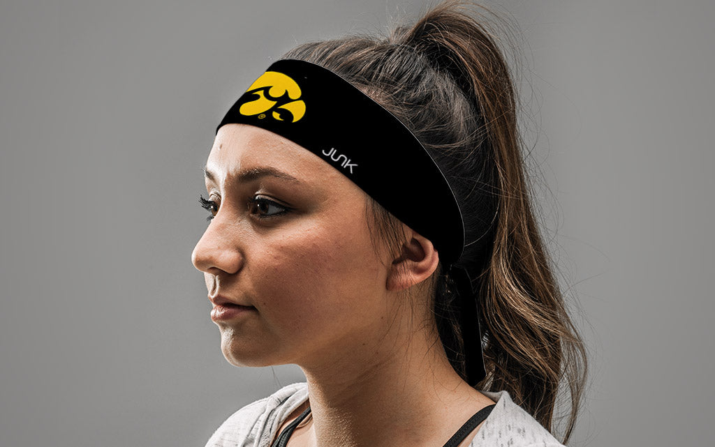 black headband with University of Iowa tiger hawk logo in gold on female
