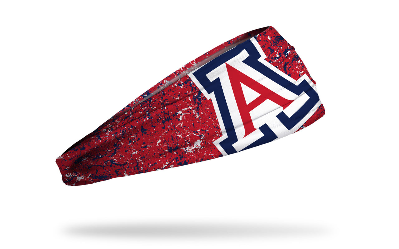 red headband with navy and white paint splatter and oversize University of Arizona A logo