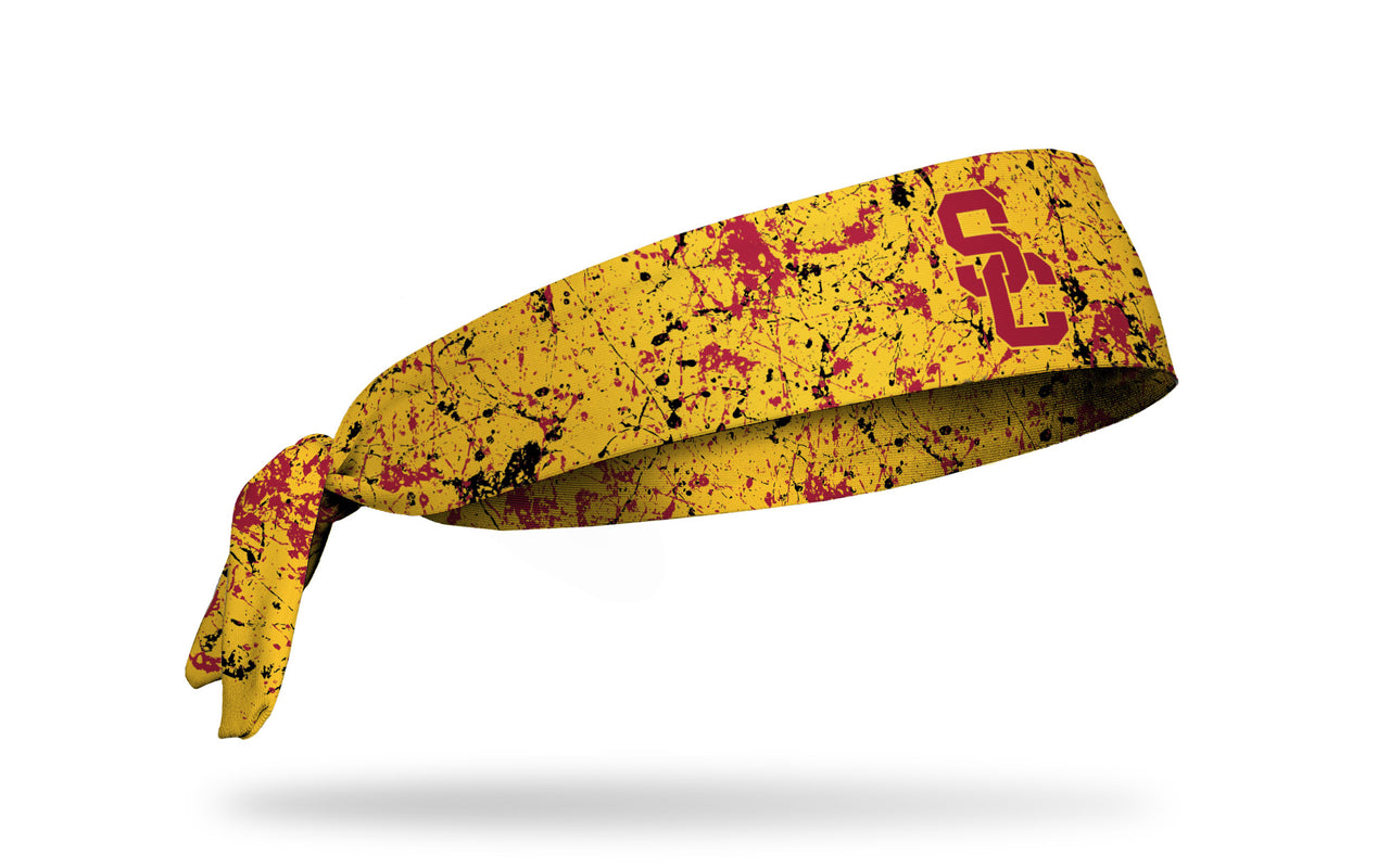 gold headband with paint splatter design and University of Southern California logo